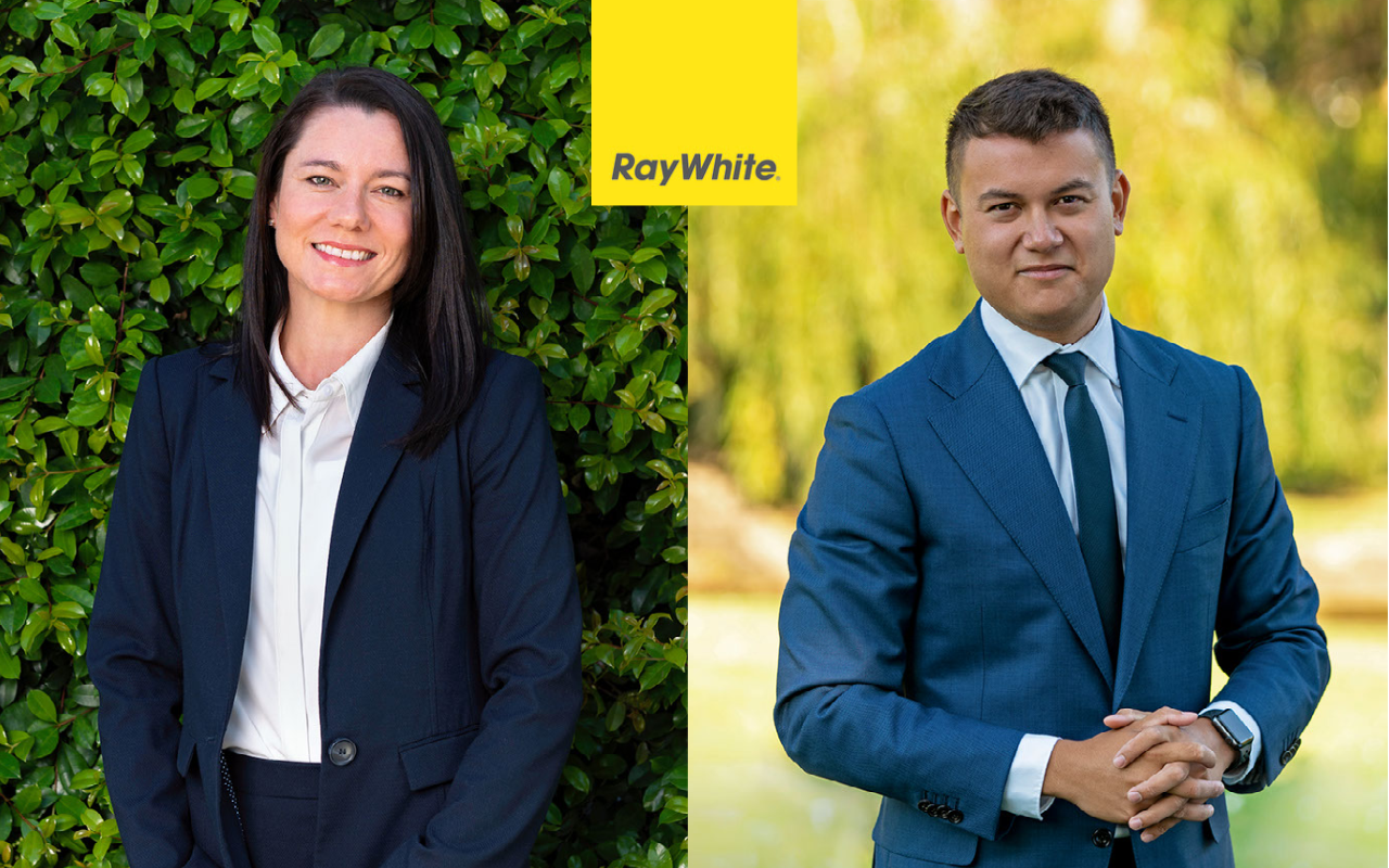 Julie Gauci and Walter Galbraith standing outside, smiling to the camera. A Ray White logo sits in between them.